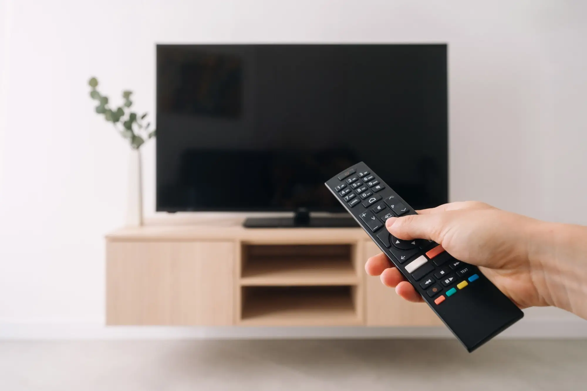 Shutterstock_2598629445 - Techsvět Ruka s ovladačem u TV