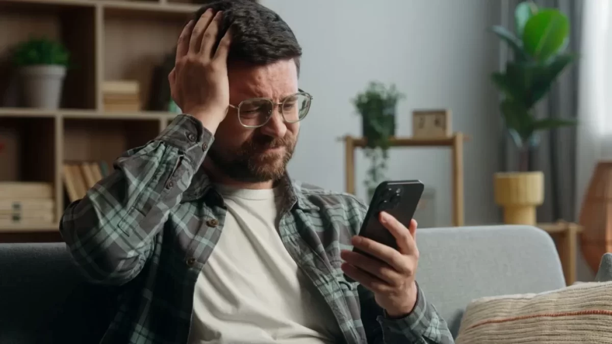 Zklamaný muž kouká do telefonu