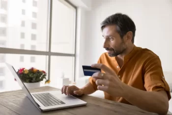 Muž s kartou u laptopu