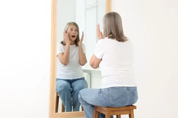 starší žena před zrcadlem