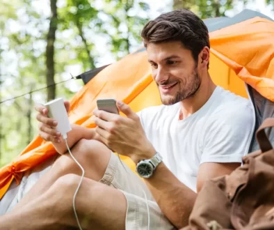 muž nabíjí telefon u stanu