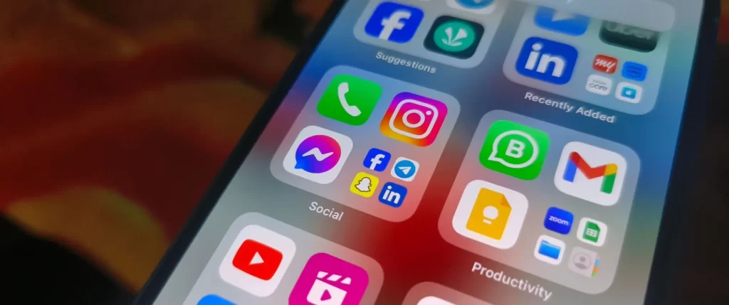 aplikace3 - Techsvět Detailní pohled na obrazovku chytrého telefonu se složkami plnými aplikací.