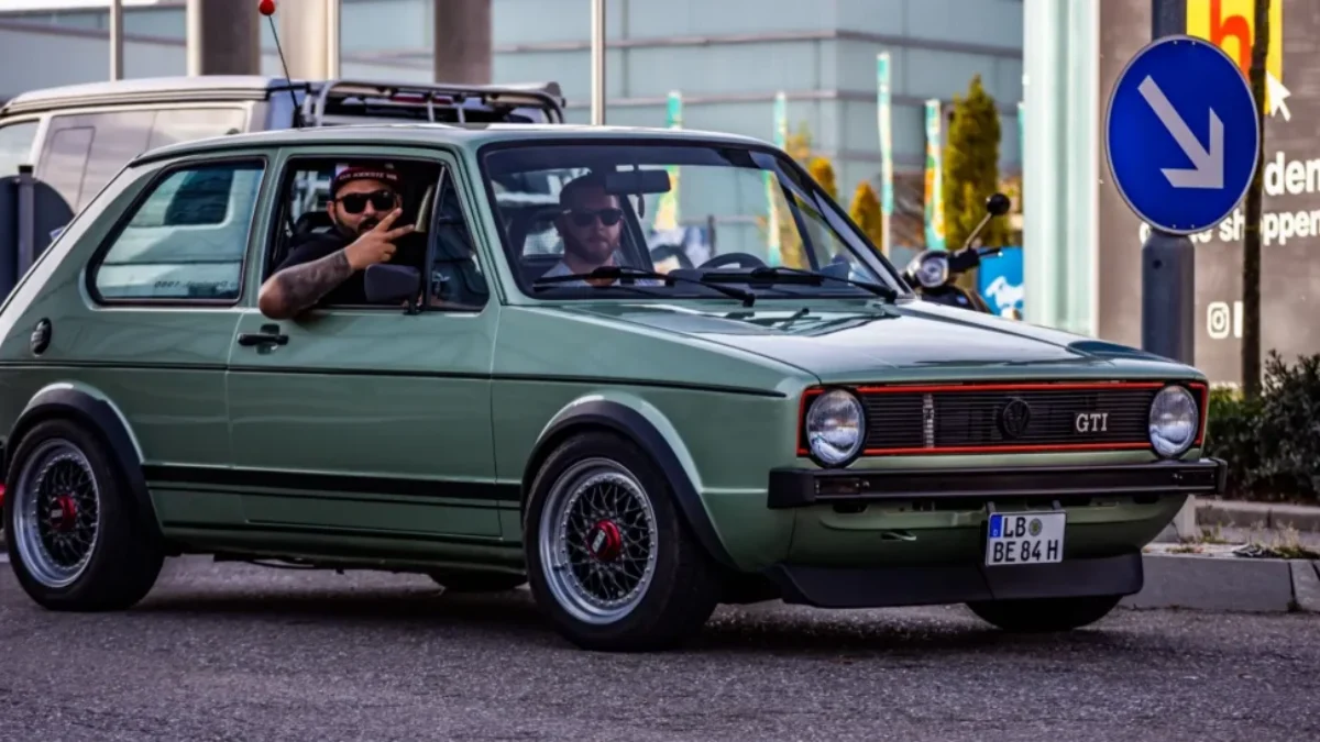 Volkswagen Golf GTI Mk1 ve skvělém stavu. Auto má typickou karoserii první generace s červeným rámečkem v masce chladiče, černými plastovými nárazníky a sportovními koly BBS.