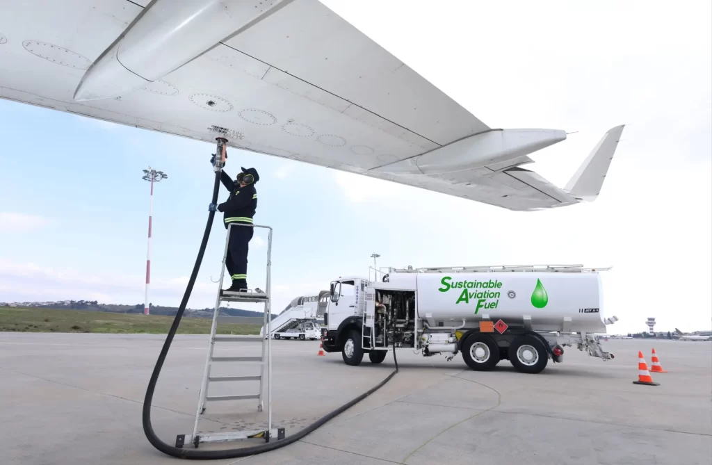 bio2 - Techsvět Pracovník tankující letadlo u křídla pomocí hadice napojené na cisternu s nápisem „Sustainable Aviation Fuel“.