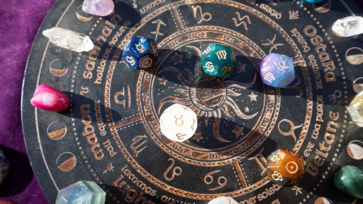 Detailní záběr na astrologický kruh se symboly zvěrokruhu a osmihranné kostky s astrologickými a planetárními znaky.