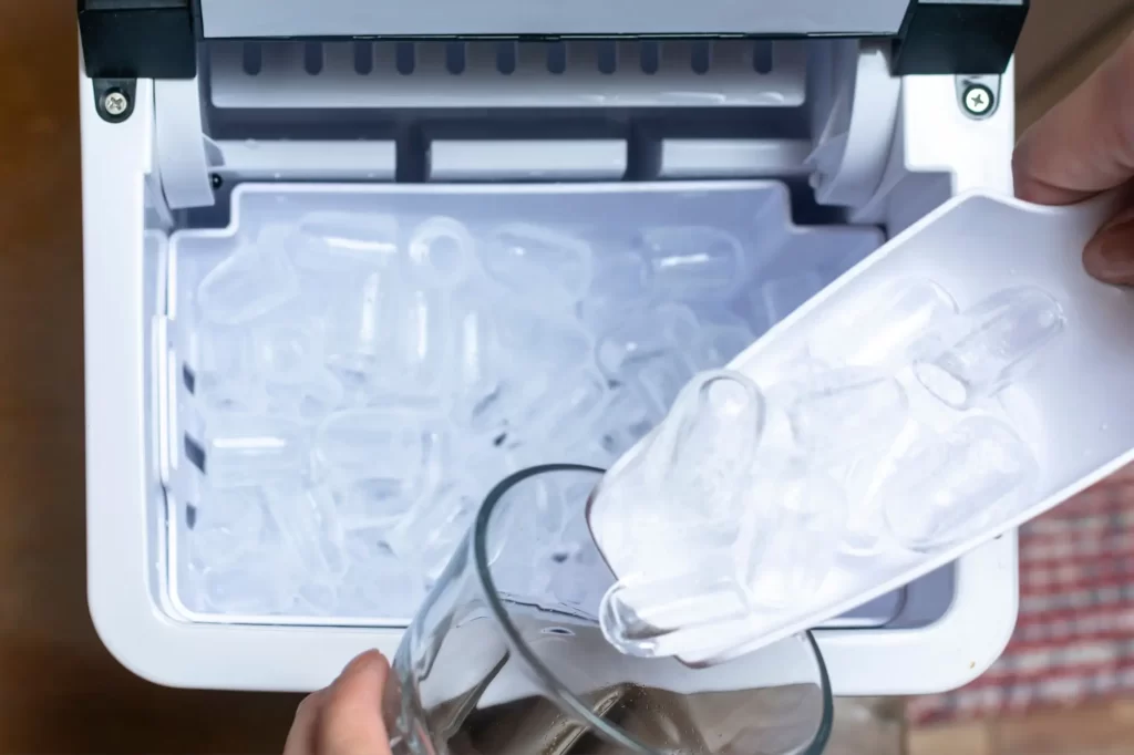 ice2 - Techsvět Domácí výrobník ledu. V přístroji je vidět zásobník plný čerstvě vyrobených ledových válečků s dutým středem, typických pro stolní výrobníky.