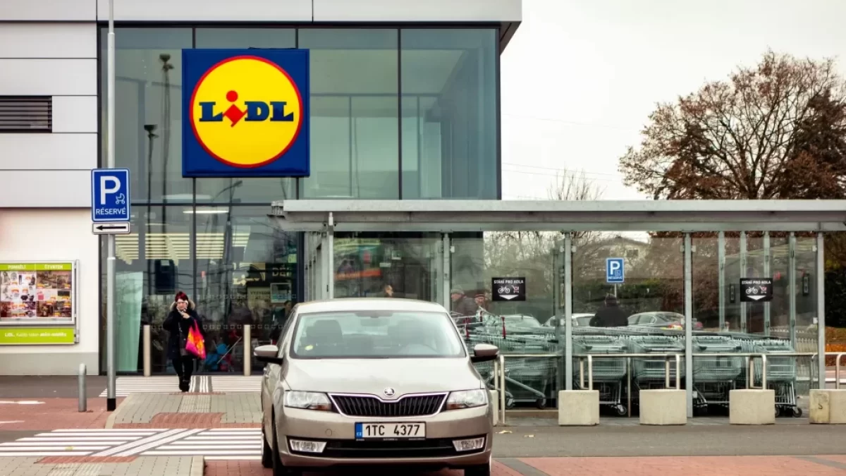 Vstup do prodejny Lidl s výrazným logem na moderní prosklené budově.