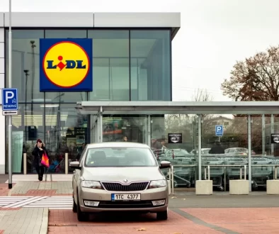 Vstup do prodejny Lidl s výrazným logem na moderní prosklené budově.