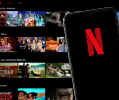 Telefon s otevřenou aplikací Netflix, kde dominuje známé červené „N“ na černém pozadí.