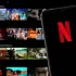 Telefon s otevřenou aplikací Netflix, kde dominuje známé červené „N“ na černém pozadí.