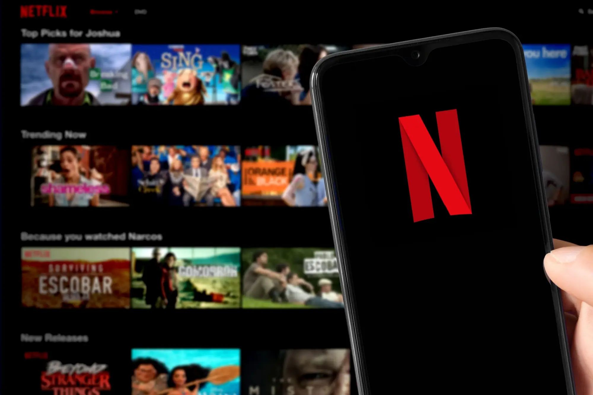 Telefon s otevřenou aplikací Netflix, kde dominuje známé červené „N“ na černém pozadí.