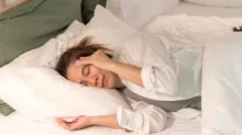 žena leží v posteli s bolestí hlavy