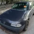 Modré auto stojí zaparkované na ulici, na čelním skle červená samolepka