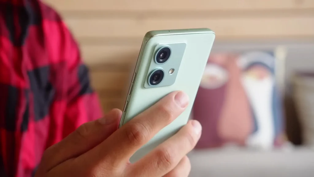 tel3 - Techsvět Ruka držící světle zelený smartphone se dvěma zadními fotoaparáty a LED bleskem