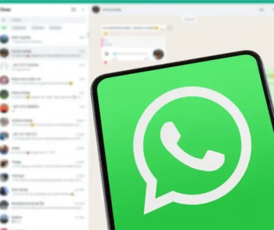 telefon s logem WA a na pozadí aplikace WA na počítači