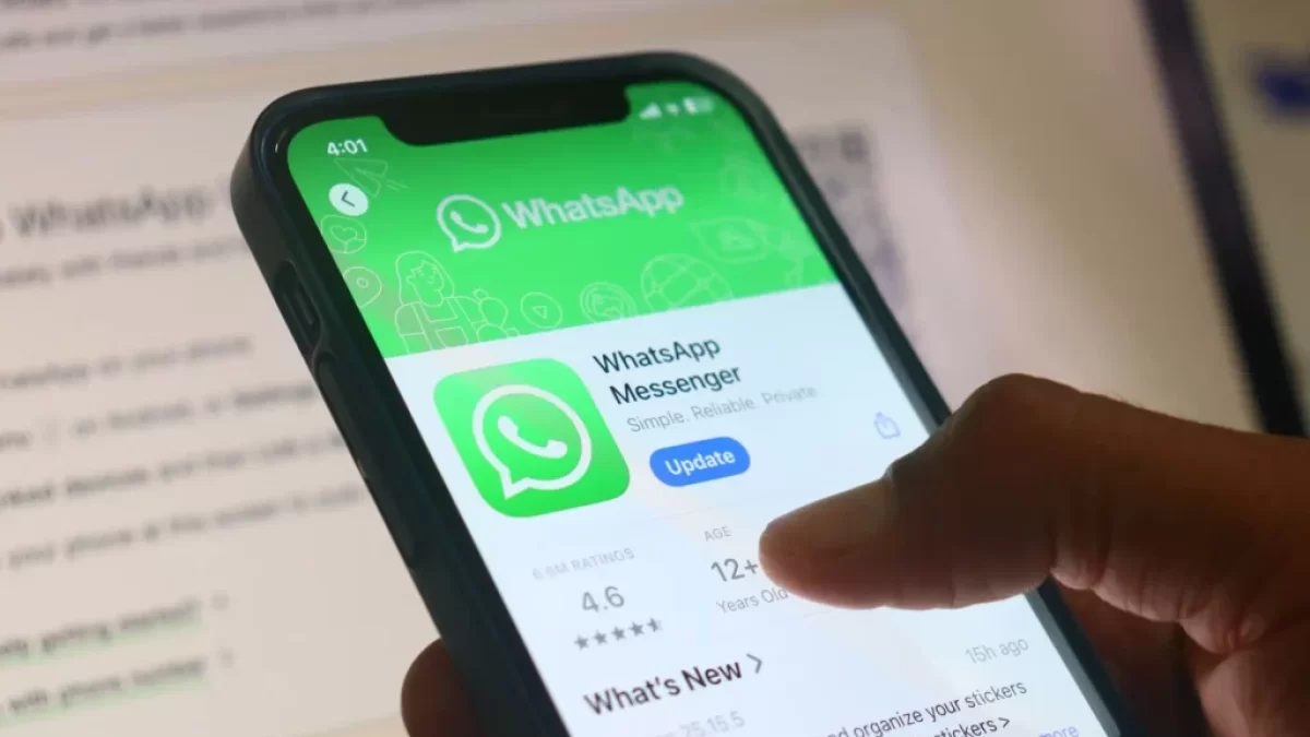 Detailní pohled na mobilní telefon, na kterém je otevřená stránka aplikace WhatsApp.