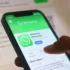 Detailní pohled na mobilní telefon, na kterém je otevřená stránka aplikace WhatsApp.