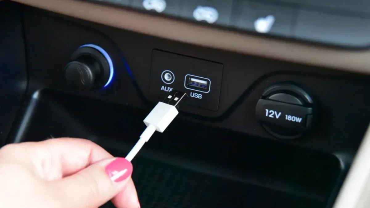 Ruka dává kabel do USB v autě