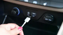 Ruka dává kabel do USB v autě