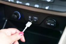 Ruka dává kabel do USB v autě