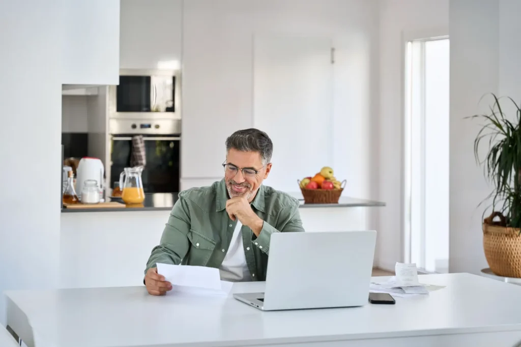Shutterstock_2423355963 - Techsvět Muž s papírem u laptopu