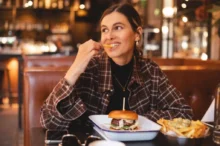 Žena jí hovězí burger