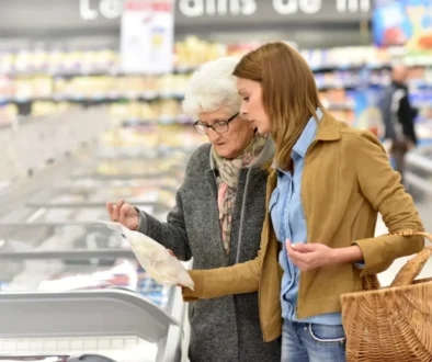 žena pomáhá s nákupem seniorce