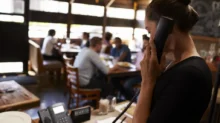 Číšnice v restauraci vyřizuje objednávky