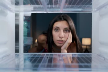 Žena kouká do lednice