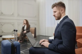 Muž v hotelovém lobby s PC