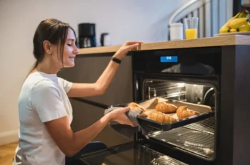 žena dává plech do trouby