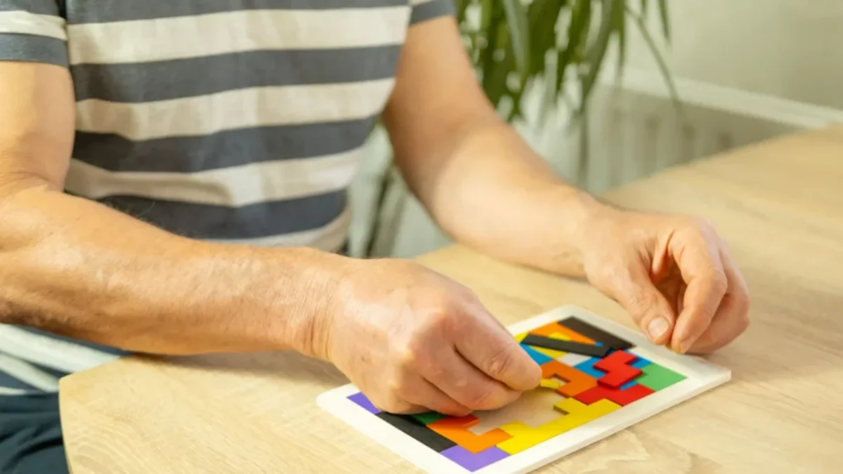 muž skládá puzzle