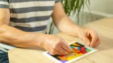 muž skládá puzzle