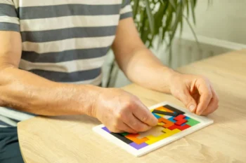 muž skládá puzzle