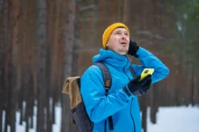 muž v lese drží telefon
