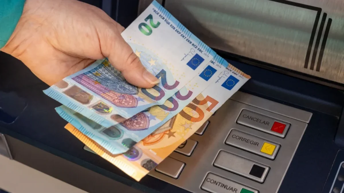 Žena vybírá peníze z bankomatu