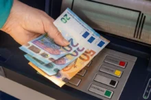 Žena vybírá peníze z bankomatu