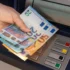 Žena vybírá peníze z bankomatu