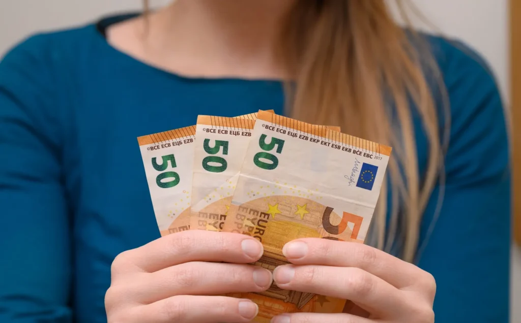 Žena drží v ruce peníze