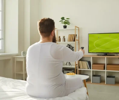 muž kouká doma na fotbal