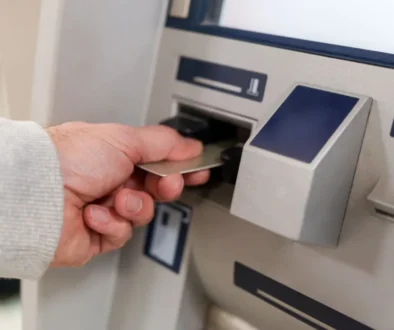 muž strká kartu do bankomatu
