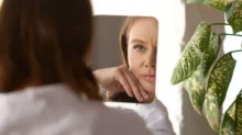 žena se dívá na sebe do zrcadla