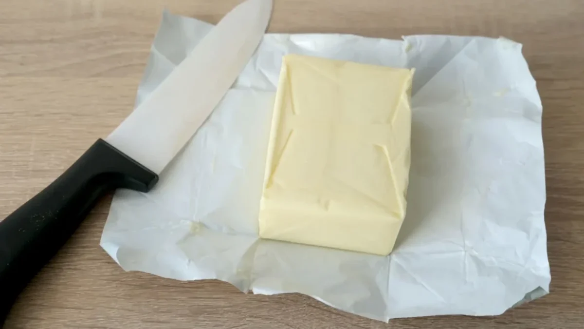 kostka másla na papíře a nůž