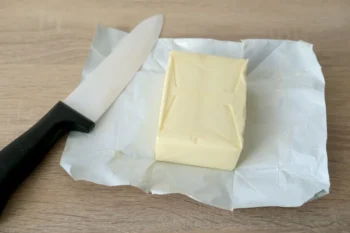 kostka másla na papíře a nůž