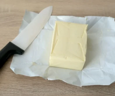 kostka másla na papíře a nůž