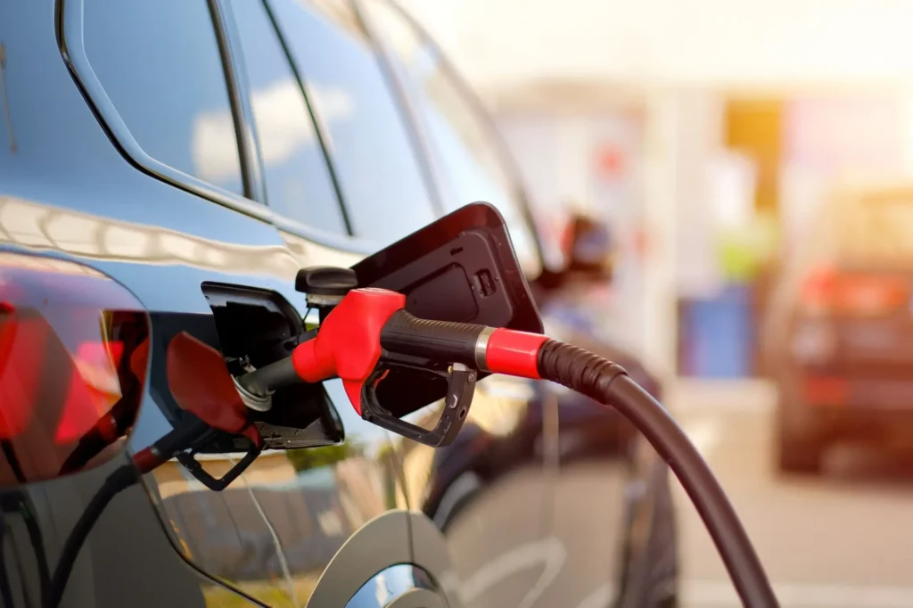 Auto s hadicí od stojany benzinky