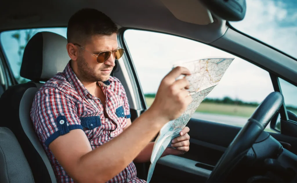 řidič hledá v mapě trasu