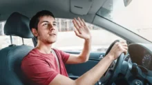 Řidič mávající za volantem