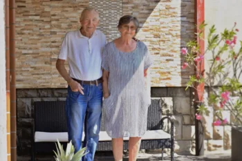 Důchodci u lavičky před domem