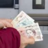 Žena s penězi u bankomatu